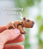 A brown articulated capybara toy with visible joints. The toy has a detailed design, including small ears, a dark nose, and blue eyes. The text "Articulating Joints" is above the toy.
