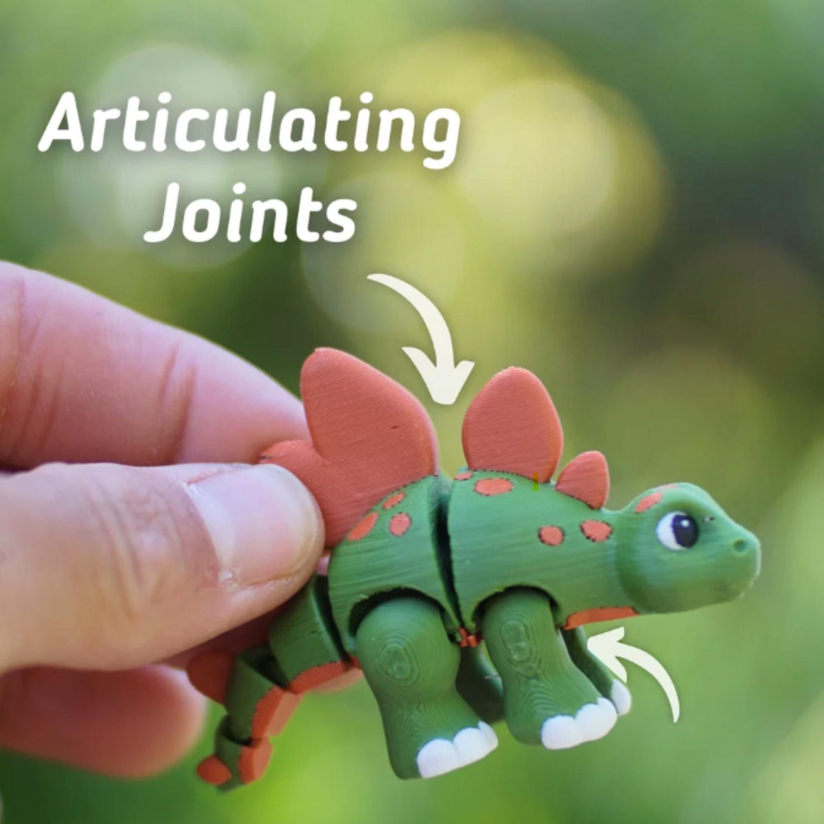 A green and orange articulated dinosaur toy with the text "Articulating Joints". The toy has a stegosaurus design with orange plates and spots. The joints are visible, allowing for movement.